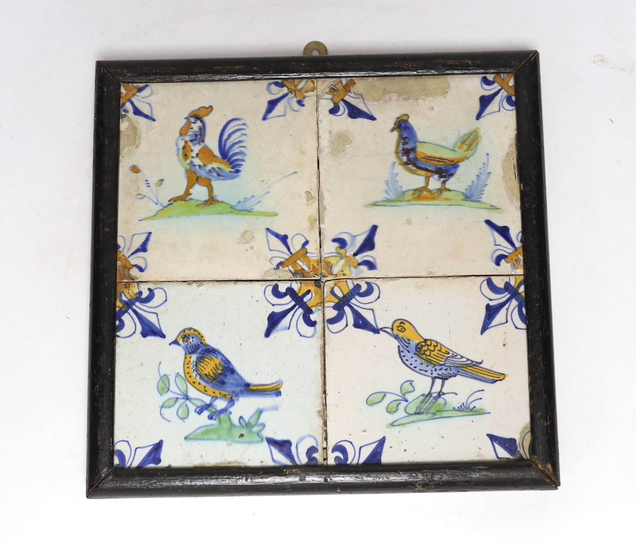 A 17th century Delft four-tile panel, polychrome-decorated with birds and with fleur-de-lys to corners (frame 28cm)